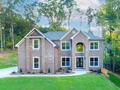 View of front of home with a front yard and brick 
