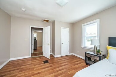 Bedroom featuring attic access, light wood-style f