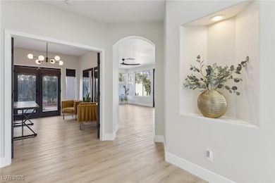 Hall with light wood-type flooring, baseboards, ar