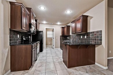 Tumbled marble back splash, granite counter-tops, bar seating, cherry custom cabinets, recessed lighting, large utility room, extra electrical outlets for easy use.