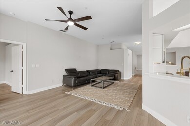 Living room featuring ceiling fan and light wood-t