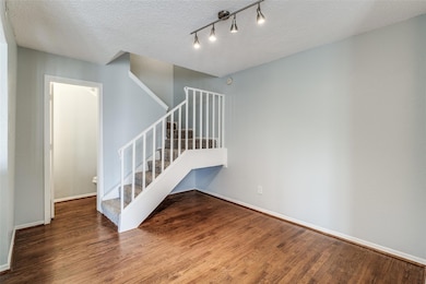 Stairs with a textured ceiling, baseboards, and wo
