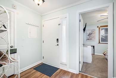 Foyer featuring crown molding, wood finished floor