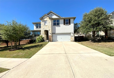 View of front of home with stone siding, stucco siding, concrete driveway, and a garage
