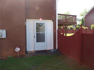 View of property exterior with brick siding and a wooden deck