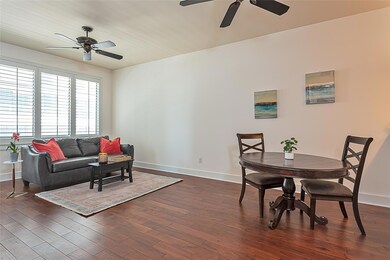 Living area with ceiling fan, baseboards, and dar