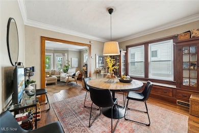 Dining room with crown molding and hardwood / wood-style floors