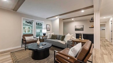 Living area with beam ceiling, light wood-style floors, baseboards, and recessed lighting