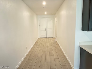 Hall with light wood-style floors and baseboards