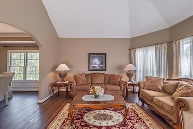 Living area featuring arched walkways, dark wood-s