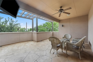 Covered third-story patio with ceiling fan and spa