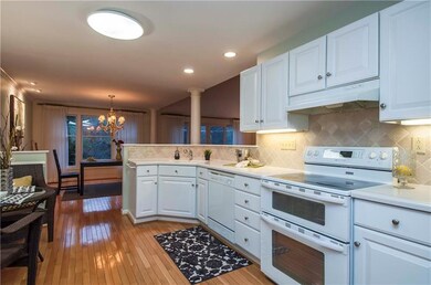 Bright cabinetry with tile backsplash and solid su