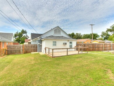 Back of house featuring a wooden deck and a lawn