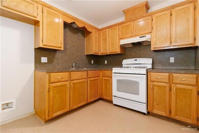 Kitchen featuring light tile floors, tasteful backsplash, sink, and white range