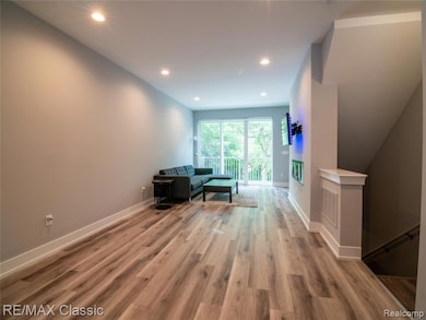 Living area with recessed lighting and light wood-type flooring
