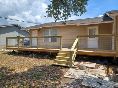 Back of house featuring a deck and roof with shin