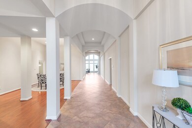 This magnificent entrance foyer features beautiful architectural details such as arched ceilings, columns and tray ceilings.  The combination living/dining room is seen on the left.