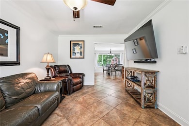 Cozy living area with neutral tones, crown molding, and tile flooring—perfect for relaxing evenings or entertaining. Large front window brings in plenty of natural light.
