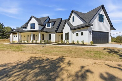 Modern farmhouse with board and batten siding, a porch, concrete driveway, and a shingled roof