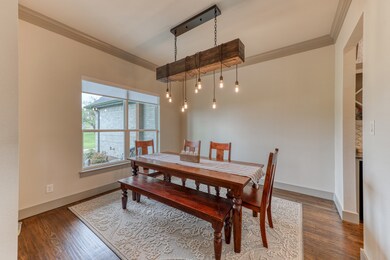 Formal dining area off front entry with passage into kitchen through butlers pantry area. Wood flooring with log beam upgraded lighting.