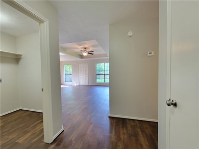 Hall with dark wood-style flooring and a textured ceiling