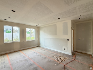 Empty room featuring baseboards and a textured ceiling