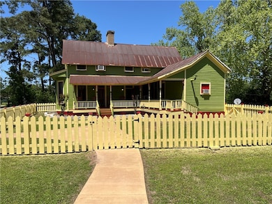 Front view of home featuring porch, front lawn, and fenced front yard