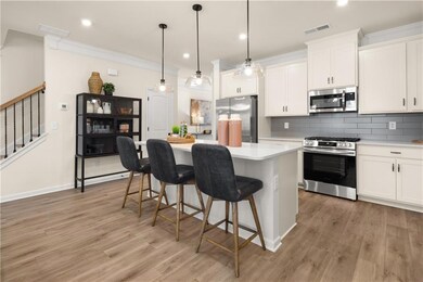 Kitchen with crown molding, visible vents, a kitch