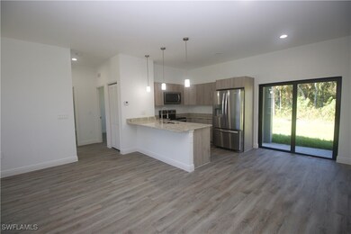 Kitchen featuring dark vinyl-type flooring, hangin