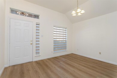 Foyer with hardwood / wood-style flooring, vaulted