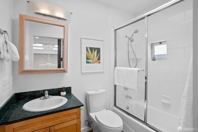 En-suite bathroom has a sliding barn-door, shower-over-tub, stone-top vanity, medicine cabinet storage, low-flush toilet, window, skylight and exhaust fan.