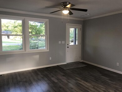 Living room has crown molding & ceiling fan