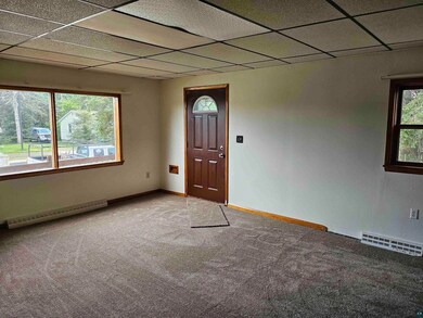 Empty room with carpet floors, a paneled ceiling, 