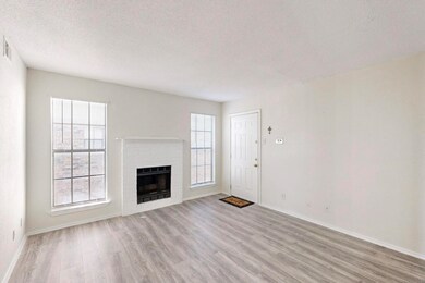 Unfurnished living room with a brick fireplace, ba