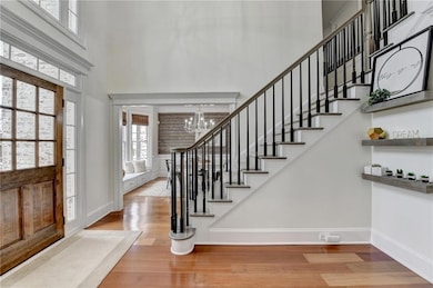 Foyer entrance with baseboards, a high ceiling, wo