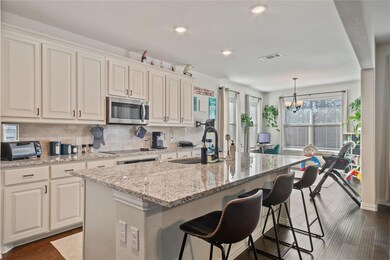 Kitchen featuring white cabinets, dark hardwood / wood-style floors, sink, and an island with sink
