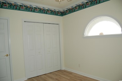 Unfurnished bedroom with light wood-style floors, a closet, and crown molding