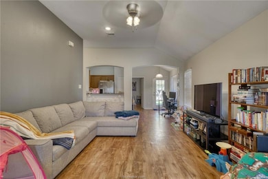 Living room featuring visible vents, arched walkwa