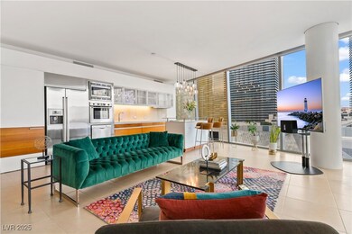 Living room with light tile patterned floors, a wall of windows, and a chandelier