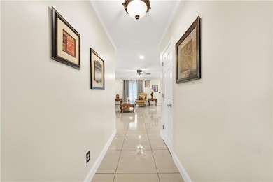 Hallway with light tile  floors and crown molding