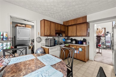Kitchen with brown cabinets, light floors, stacked