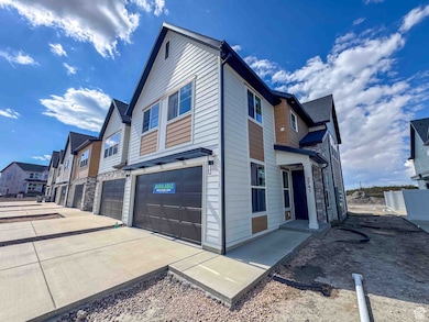 View of side of home featuring a residential view, a garage, stone siding, and concrete driveway