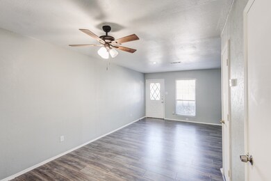 Empty room with dark wood-type flooring, ceiling fan, and a textured ceiling