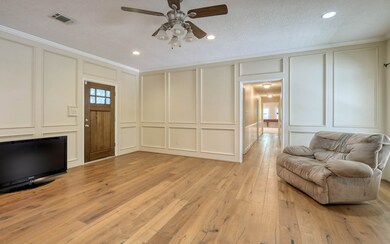 Spacious Family room with block paneling, recessed lights, fireplace and engineered wood floors.