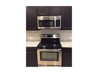 Kitchen featuring appliances with stainless steel finishes, light stone counters, and backsplash