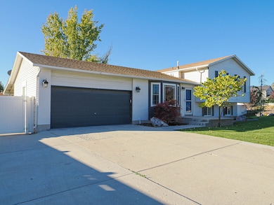 View of front of property with concrete driveway, brick siding, an attached garage, and a front yard