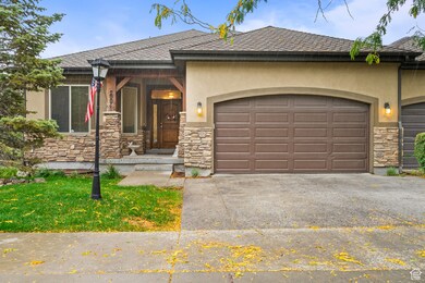 View of front of property with stone siding, a porch, a shingled roof, and stucco siding
