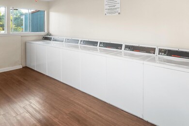 Community laundry featuring wood finished floors 