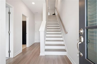 Stairway featuring wood finished floors, baseboards, and recessed lighting