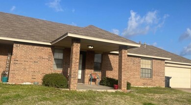 Back of property with a garage and a yard